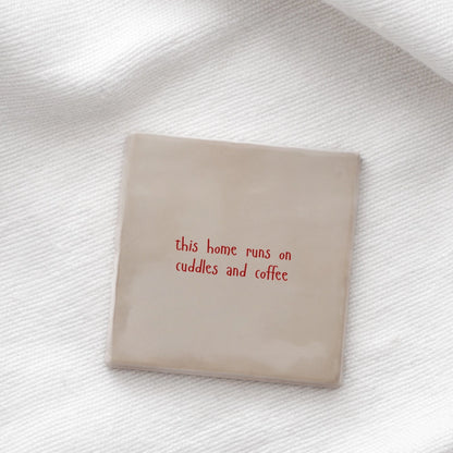 Tegeltje : "This home runs on cuddles and coffee" - roze